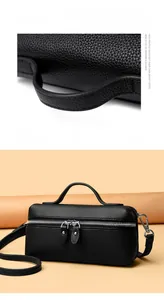 Macro detail of high-quality litchi grain cowhide leather handle and silver zipper on bag