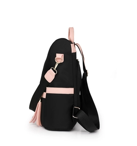 Side view of black nylon backpack with pink leather trim and decorative tassel charm