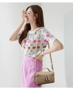 Detail of khaki lychee grain leather handbag with top handle and slim shoulder strap