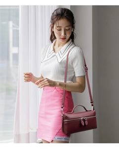Close-up of wine red lychee pattern leather handbag with dual zipper and metal hardware