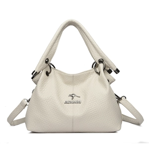 Dettaglio borsa in pelle color crema con trama a litchi e tracolla regolabile