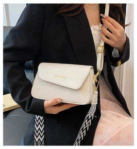 Détail du sac bandoulière blanc cassé avec rabat tissé et fermoir en métal doré