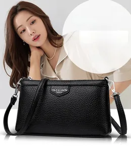 Vue détaillée du cuir grainé noir et des ferrures métalliques argentées d'un sac à bandoulière