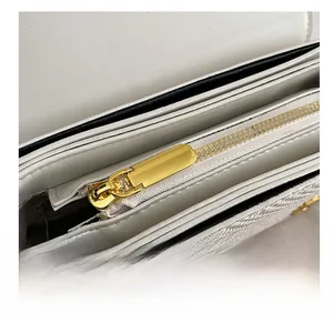 Détail de la fermeture éclair en métal doré et des compartiments internes de ce sac