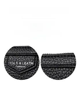 Détail de couture de précision et cuir grainé sur un sac à bandoulière noir