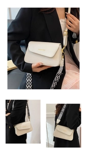 Détail du sac bandoulière crème avec texture tissée et large bandoulière géométrique