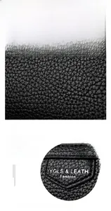 Détail macro du cuir grainé noir et du logo gaufré sur ce mini portefeuille élégant