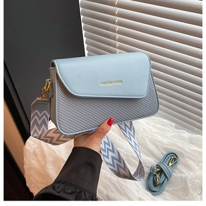 Détail du petit sac carré bleu clair avec texture tissée et large bandoulière jacquard