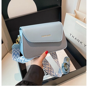Détail du sac à bandoulière bleu clair avec texture tissée et deux sangles interchangeables