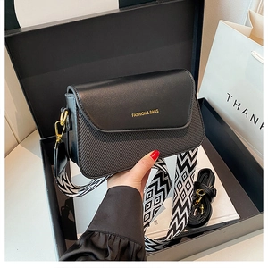 Détail du sac bandoulière noir en cuir et tissu avec large bandoulière géométrique