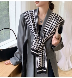 Detail of knitted houndstooth shawl featuring black and white contrast striped edges