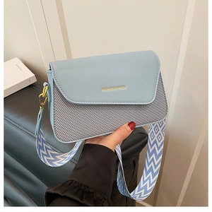 Détail du petit sac bandoulière bleu clair en cuir PU avec large sangle à motifs et doré