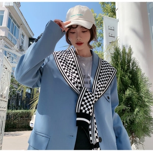 Chic black and white houndstooth knit shawl over a light blue casual blazer jacket