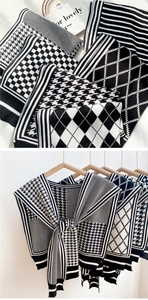 Detail of knit shawl featuring houndstooth and checkered patterns on a wooden hanger