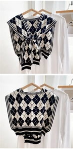 Detail of black and white argyle knitted shawl wrap with textured jacquard finish