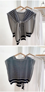 Detail of black and white striped knitted shawl vest featuring a versatile tie-front design