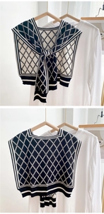 Detail of black and white houndstooth knit shawl with diamond pattern and soft texture