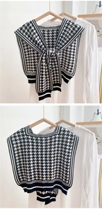 Detailed knit texture of houndstooth shawl and striped border on white background