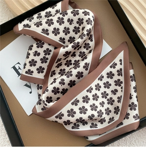 Gros plan détaillé d'un foulard en soie aux tons terre avec motifs floraux bruns