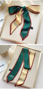 Détail d'un élégant foulard en soie tricolore avec couture raffinée sur un plateau doré