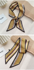 Gros plan d'un foulard étroit jaune moutarde à pois noirs et fines rayures élégantes