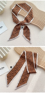 Détail d'un foulard en soie caramel avec motifs d'éléphants et imprimés géométriques