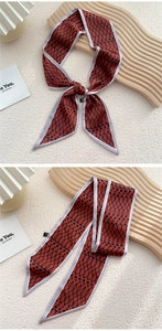 Détail d'un foulard en soie rouge à motif géométrique noué sur un présentoir décoratif