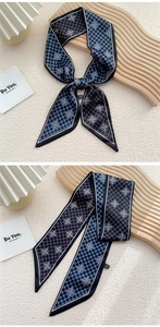 Détail d'un foulard en soie à damier bleu avec motif en croix sur support céramique