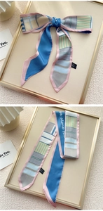 Détail d'un foulard Twilly en soie color-block avec rayures et un élégant nœud papillon