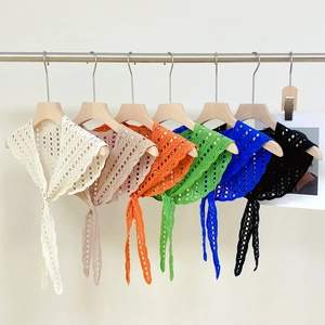 Detail of multi-color crochet shawls with polka dot cutouts and tie-up design