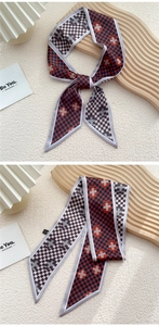 Gros plan d'un foulard en soie à damier bleu marine et orange sur un plateau en bois