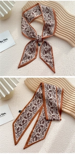 Détail d'un foulard en soie élégant à motif cachemire et bordure orange satinée