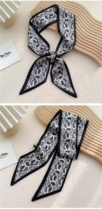Détail d'un foulard en soie paisley noir et blanc utilisé comme bandeau ou bijou de sac