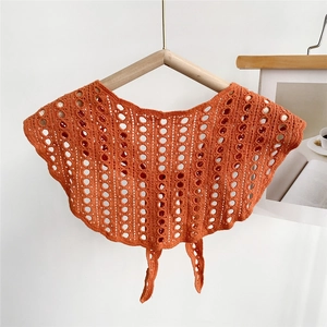 Detail of ginger orange hollow crochet knit shawl with retro pattern and front ties