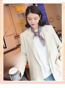 Close-up of a brown and black checkered neck scarf styled on a model in a cafe