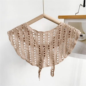 Detailed view of beige crochet hollow capelet with scalloped edges and front tie string