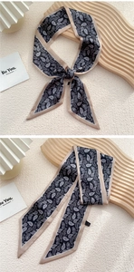 Détail d'un foulard en soie à motif cachemire noir avec bordure élégante en satin champagne