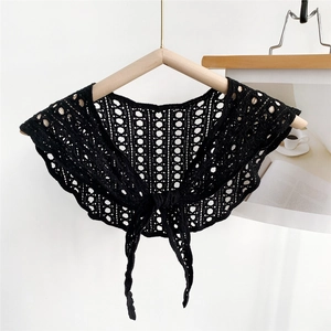 Detail of black crochet hollow shawl with geometric patterns and front tie strings