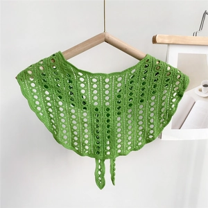 Close-up of green crochet hollow shawl wrap with intricate floral patterns and ties