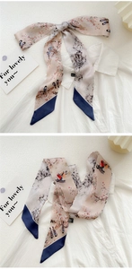 Detailed shot of floral print narrow scarf with bird motifs tied on a white shirt collar