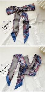 Detail of vintage paisley print silk scarf tied as a bow on a white collared shirt