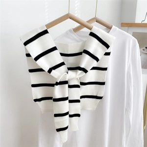 Close-up of black and white striped knitted decorative shawl collar knotted on a white shirt