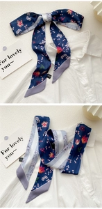 Detail of navy blue floral skinny scarf tied on white shirt showing tulip print texture