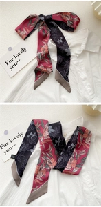 Detail of pink and black floral silk scarf tied as a bow on a white collared shirt