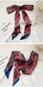 Detail of vintage oil painting style skinny silk scarf tied as an elegant neckerchief