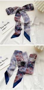Detail of oil painting style silk scarf worn as a bow on a white shirt collar