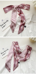 Close-up of floral print twilly silk scarf tied in a bow on a white shirt collar