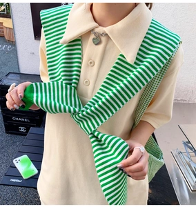 Outdoor street style view of beige waffle knit polo shirt with green striped shawl