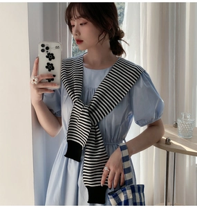 Detail of classic black and white striped knit shawl with faux sleeve ribbed cuffs decoration