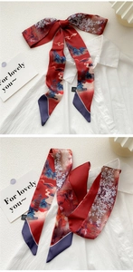 Close-up of red oil painting silk twilly scarf tied on a white shirt as a bow
